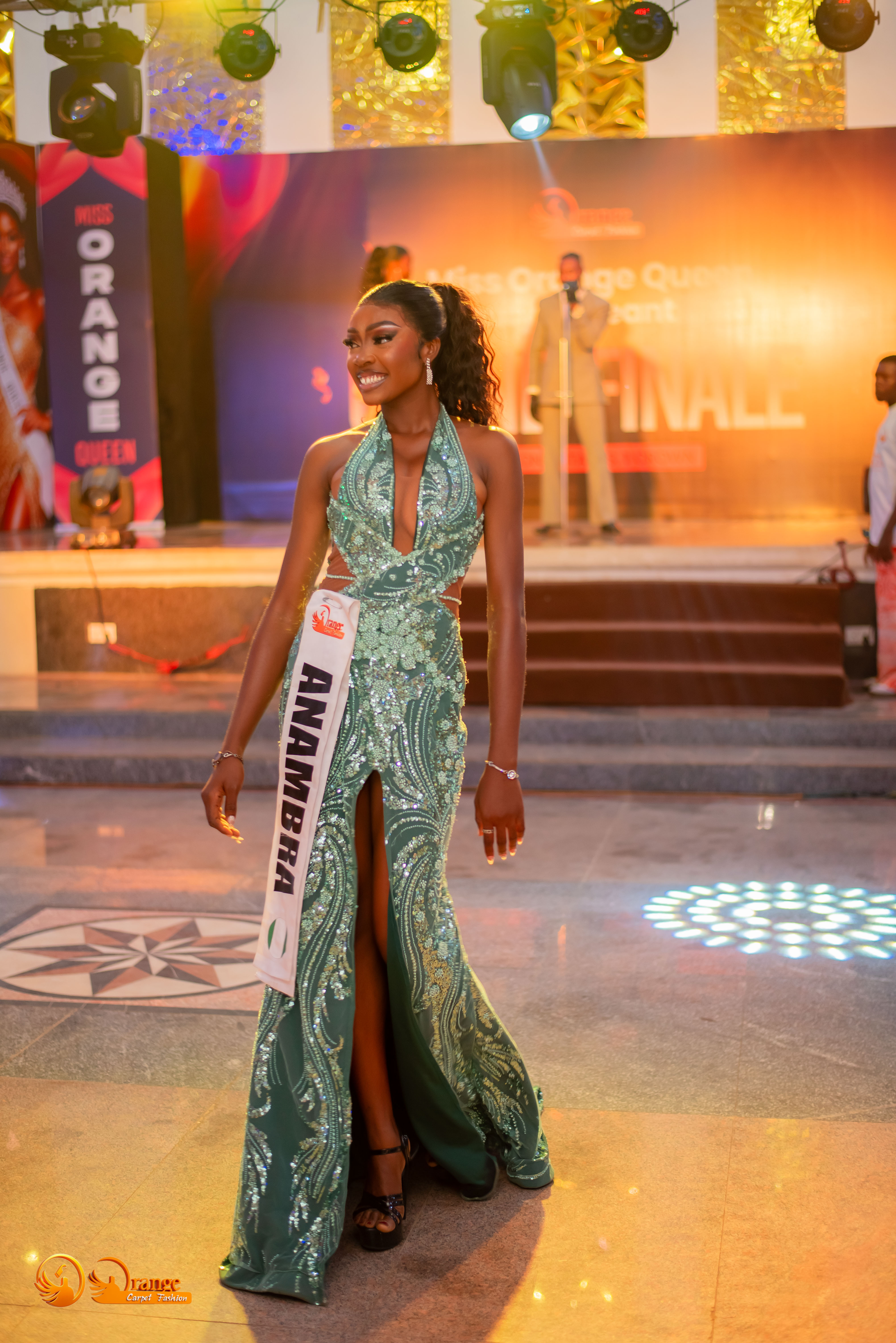 Abigael walking the runway in a green sequined gown at Miss Orange Queen grand finale