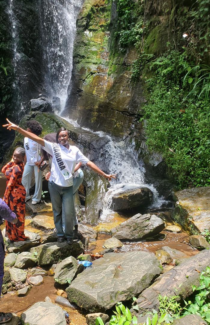 Abigael celebrating at a waterfall during community outreach